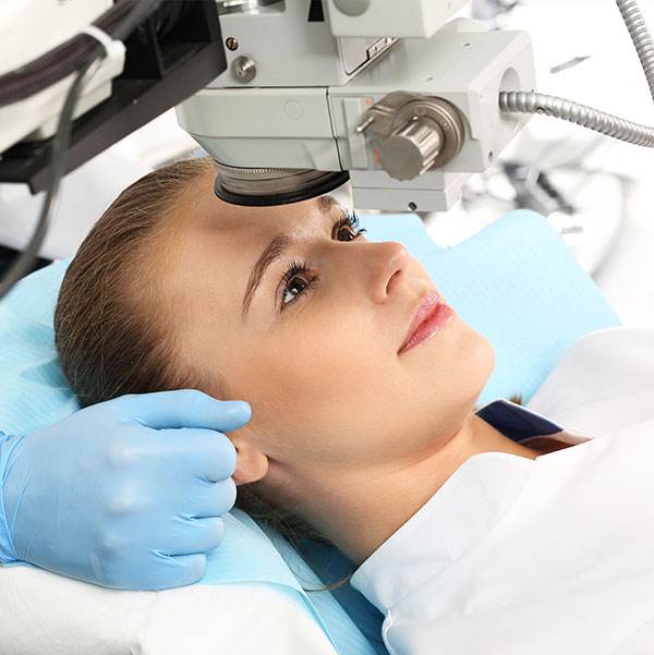 A woman lies on a treatment chair waiting for surgery